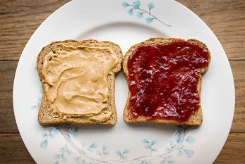 two pieces of bread on a plate with peanut butter and jelly on them